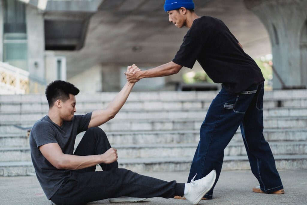 Asian man helping friend to get up from ground. Why Can Bro Code Harm Women